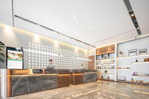 a lobby of a store with a man standing at a counter at Atour Hotel Luqiao Taizhou in Taizhou