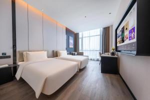 Habitación de hotel con 2 camas y TV de pantalla plana. en Atour Hotel Xiapu Fujian, en Fuzhou