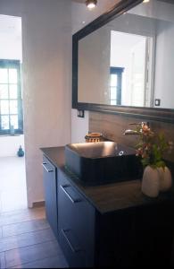 uma casa de banho com um lavatório e um espelho grande em Maison calme - Frontière Montagne et Plage em Urrugne