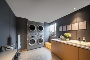 a laundry room with three washing machines and a sink at Atour X Hotel Hangzhou Wenyi Road in Hangzhou