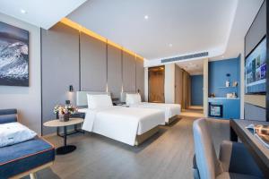 um quarto de hotel com duas camas e um sofá em Atour Hotel Jincheng Gaoping High-Speed East Railway Station em Gaoping