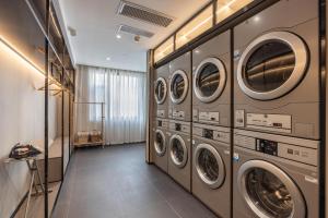 a laundry room with a row of washers and dryers at Atour Hotel Lanzhou Railway Bureau in Lanzhou