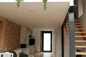 a living room with a staircase and a kitchen at O Cabanel in Fisterra