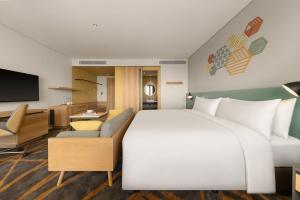 Habitación de hotel con cama grande y TV en HIIVE by Fusion Binh Duong, en Thuan An