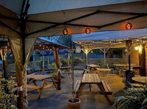 patio ze stołami i parasolami w restauracji w obiekcie The Plough Inn w mieście York