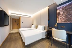 延吉市にあるAtour X Hotel Yanji Department Store West Marketのベッドルーム1室(白いベッド1台、白い椅子2脚付)