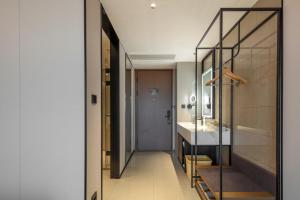a hallway with a glass door leading to a bathroom at Atour Hotel Hangzhou East Railway Station West Square in Hangzhou