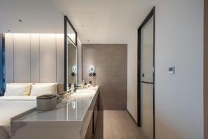 Un baño con dos lavabos y un espejo grande. en Atour Hotel Tonglu City Center Hangzhou, en Xiaoba 20 fotos más