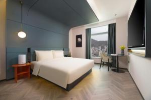 蘭州市にあるAtour S Hotel Lanzhou Asia-Europe International High Altitudeのベッドルーム(白い大型ベッド1台、デスク付)