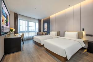 Cette chambre comprend 2 lits et une télévision à écran plat. dans l'établissement Atour Hotel Taizhou Linhai Toumen Port, à Linhai