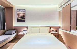 1 dormitorio con 1 cama grande y 1 sofá en Atour X Hotel Chuxiong Yihai Park, en Chuxiong