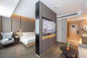 a hotel room with a bed and a flat screen tv at Atour Hotel Lanzhou Railway Bureau in Lanzhou