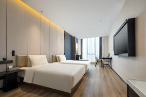 een hotelkamer met 2 bedden en een flatscreen-tv bij Atour X Hotel Changzhou Jintan District Government in Jintan