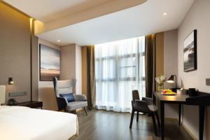 a hotel room with a bed and a desk and a table at Atour Hotel Kunshan Chengdong Development Zone in Kunshan