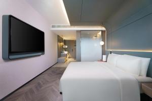 a bedroom with a white bed and a flat screen tv at Atour S Hotel Lanzhou Asia-Europe International High Altitude in Lanzhou