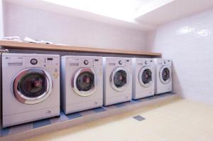 a row of washers and dryers in a laundry room at Uniqstay in Busan