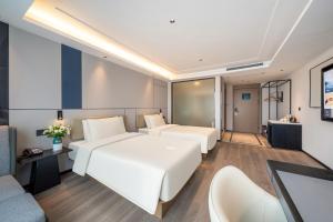 杭州市にあるAtour X Hotel Hangzhou Wenyi Roadのベッド2台とテレビが備わるホテルルームです。