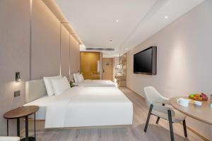 um quarto de hotel com uma cama grande e uma mesa em Atour X Hotel Xi'an Northwestern Polytechnical University Subway Station em Xian
