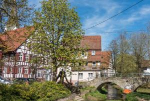 an old bridge in front of houses and a tree at Ferienwohnung Milla in Weissach Im Tal