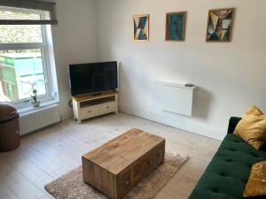 a living room with a couch and a tv at Alsager Town Centre Apartment in Alsager