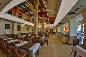 - un restaurant avec des tables et des chaises dans une salle dans l'établissement Hotel Olimp, à Zlatibor