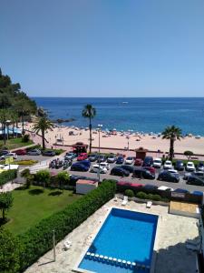 a parking lot with a swimming pool and a beach at Apartamento Sol- Fanals in Lloret de Mar