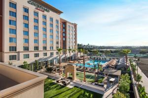 une image d'un hôtel avec une piscine et des palmiers dans l'établissement Courtyard by Marriott Irvine Spectrum, à Irvine