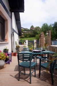 a patio with tables and chairs on a deck at Maison calme - Frontière Montagne et Plage in Urrugne