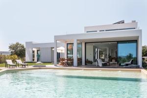 a house with a swimming pool in front of a house at Villa Arrabida in Quinta do Conde