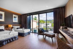Una habitación de hotel con dos camas y un televisor. en New Luxury Two bedroom private swimming pool villa with complete supporting facilities, convenient for travel 800 meters to Kamala Beach H09, en Kamala Beach