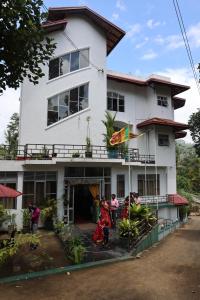 a group of people standing outside of a building at Paramount Hotel Pussellawa in Pussellawa