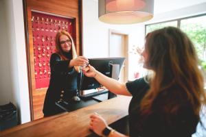 Eine Frau, die an einer Bar sitzt und ein Glas hält. in der Unterkunft Marienhöh - Hideaway & Spa in Langweiler