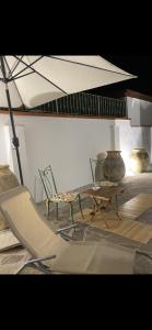 um quarto com uma cadeira, uma mesa e um guarda-chuva em Casa Raffaela em Marina di Pisa