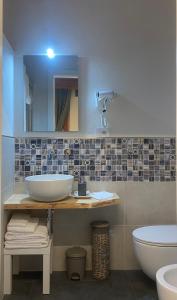 a bathroom with a sink and a toilet and a mirror at Casa Raffaela in Marina di Pisa