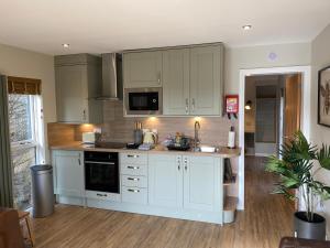 a kitchen with white cabinets and a counter top at Beechnut Lodge with Hot Tub in Cupar