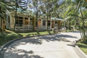 a house with palm trees in front of a driveway at Best Way Resort in Pak Chong