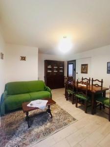 a living room with a green couch and a table at Casa Tatone in Roccaraso