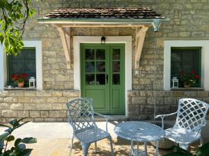 two chairs and a table in front of a house at Erdős Vendégház Pécsely in Pécsely