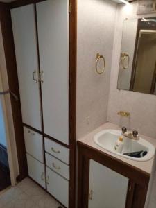 małą łazienkę z umywalką i lustrem. w obiekcie KAMPER NAD BRZEGIEM JEZIORA NIEGOCIN w mieście Giżycko