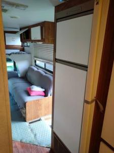 um quarto com um sofá e uma cama num trailer em KAMPER NAD BRZEGIEM JEZIORA NIEGOCIN em Giżycko
