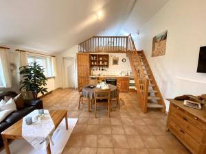 ein Wohnzimmer mit einer Wendeltreppe und einem Tisch in der Unterkunft Eichenhof III in Grothusenkoog