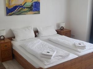 a bed with white sheets and white towels on it at Hotel Brandaris in Langeoog