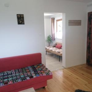 ein Wohnzimmer mit einem roten Sofa und einer Bank in der Unterkunft Apartmaji BORŠTNER in Vransko