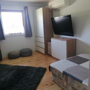 a bedroom with a bed and a flat screen tv at Apartmaji BORŠTNER in Vransko