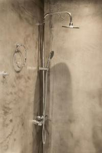 uma casa de banho com uma cabeça de chuveiro em Ammos Luxury Suite em Caristo