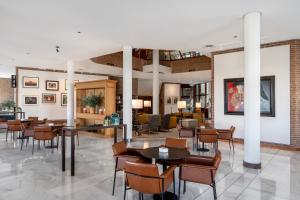 un hall avec des tables et des chaises dans un bâtiment dans l'établissement Parador de Ronda, à Ronda