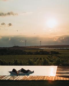 eine Person auf einem Deck mit Sonnenuntergang im Hintergrund in der Unterkunft Methe in Lizzano