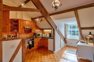 a kitchen with wooden cabinets and a stove top oven at Finest Retreats - Valley View in Camelford