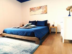 Schlafzimmer mit einem Bett mit blauer Bettwäsche und einem Teppich in der Unterkunft sous les deux tours - SWEET JANE apartment in Bologna