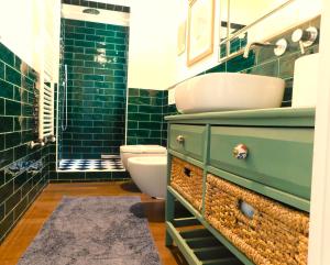 ein Badezimmer mit einem grünen Schrank mit einem Waschbecken und einem WC in der Unterkunft sous les deux tours - SWEET JANE apartment in Bologna